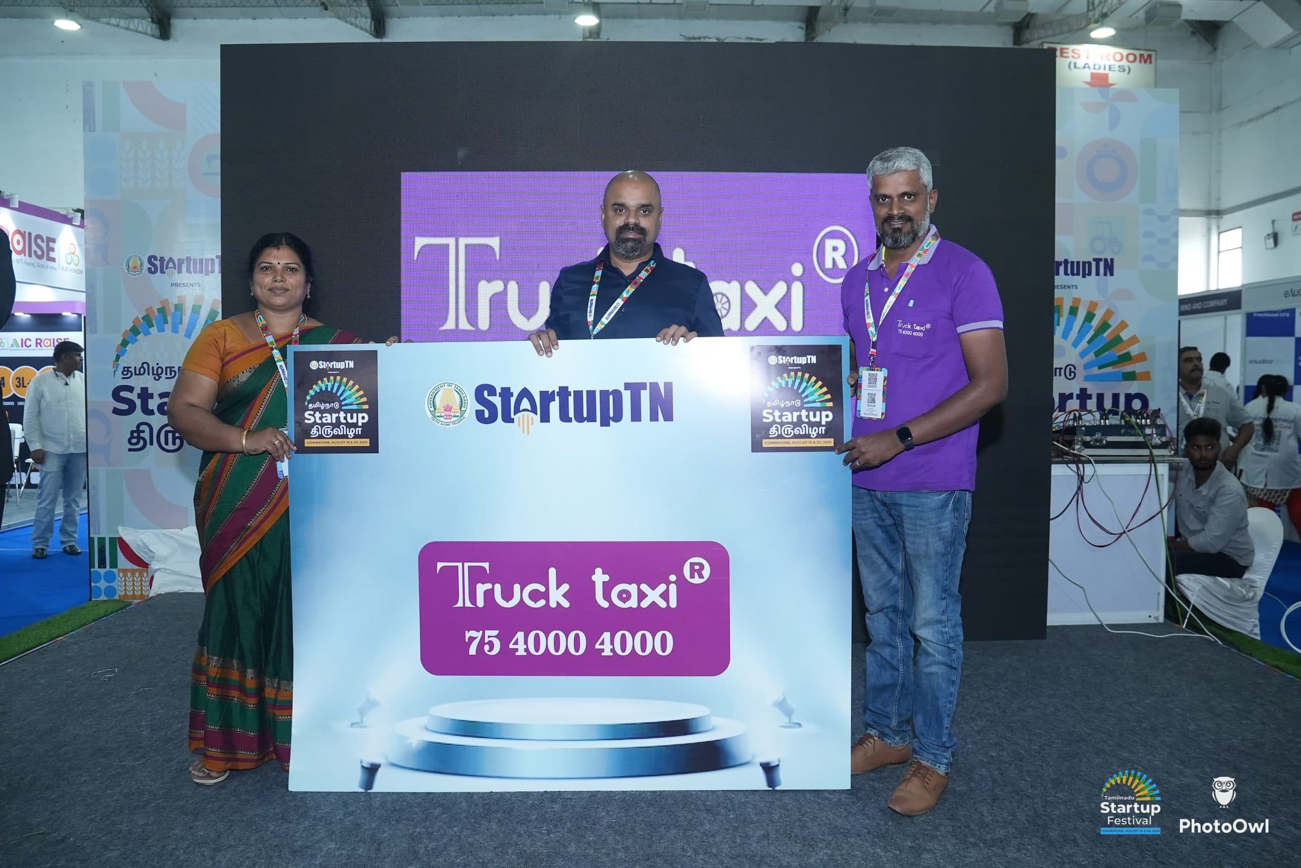 Maran with two members of the Truck Taxi team holding a branded board at the Tamil Nadu Startup Festival