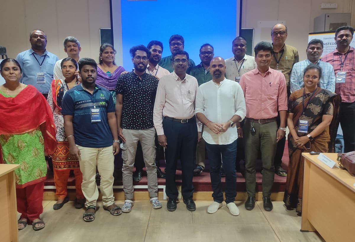A group of around sixteen programme participants on an auditorium stage